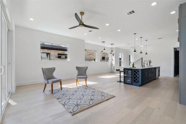 living area featuring sink, ceiling fan, and light hardwood / wood-style flooring