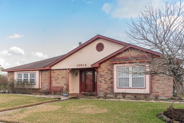 ranch-style home featuring brick siding and a front lawn