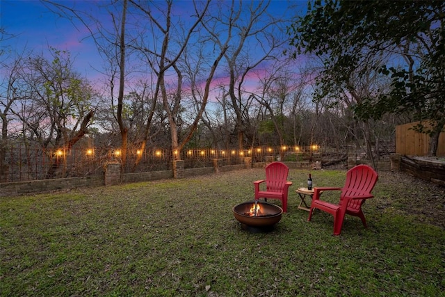 yard at dusk featuring a fire pit