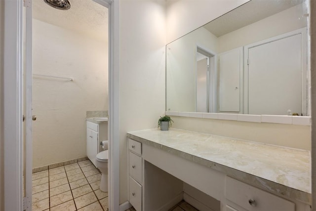 bathroom with vanity, a textured ceiling, and toilet