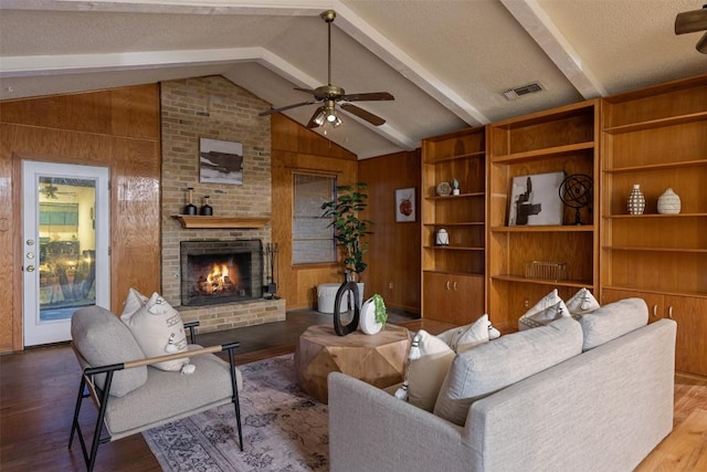 living room featuring a brick fireplace, hardwood / wood-style flooring, lofted ceiling with beams, and wood walls