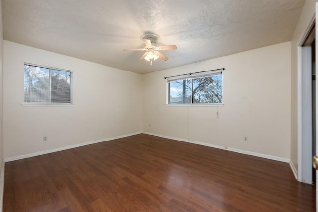 unfurnished room featuring ceiling fan, dark wood-type flooring, and a textured ceiling