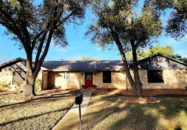 2000 Donna Dr, Taylor, TX 76574 - ranch-style home featuring a front yard, stone siding, and roof with shingles