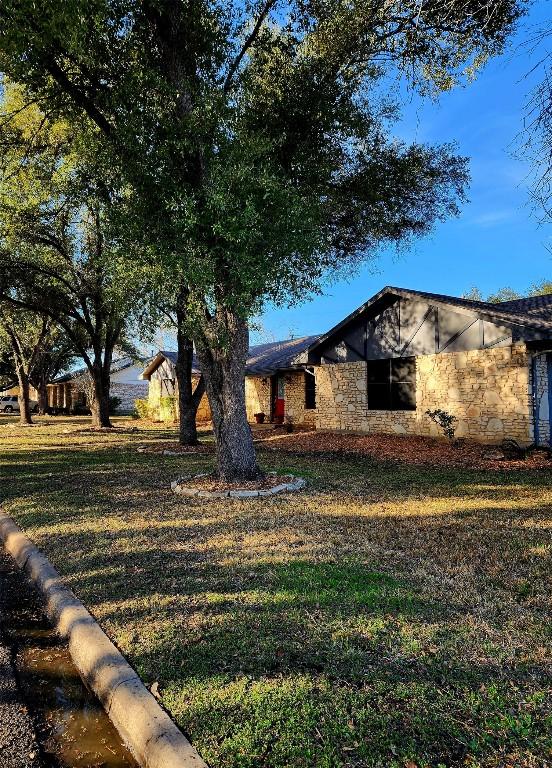 2000 Donna Dr, Taylor, TX 76574 - mid-century modern home with stone siding and a front lawn