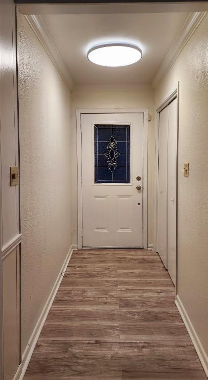 entryway featuring crown molding and hardwood / wood-style floors