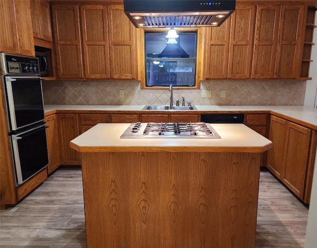 kitchen with light hardwood / wood-style flooring, a center island, sink, and black appliances