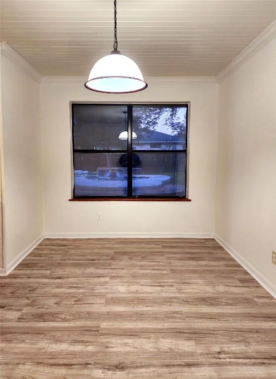 spare room featuring crown molding and wood-type flooring