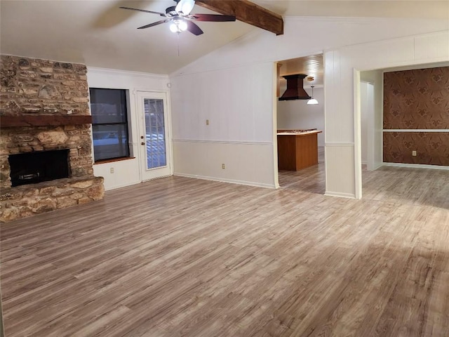 unfurnished living room with lofted ceiling with beams, ceiling fan, a fireplace, and light hardwood / wood-style floors