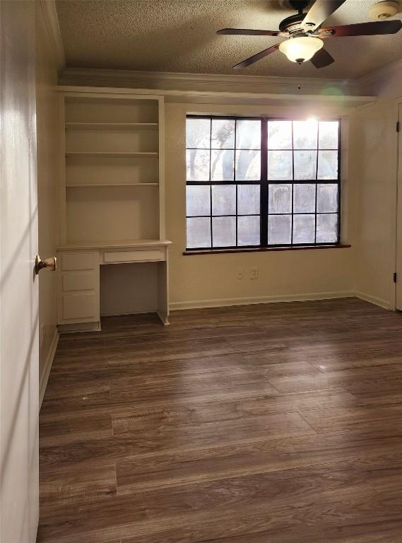 2000 Donna Dr, Taylor, TX 76574 - unfurnished room with ceiling fan, a textured ceiling, crown molding, dark wood-style flooring, and plenty of natural light