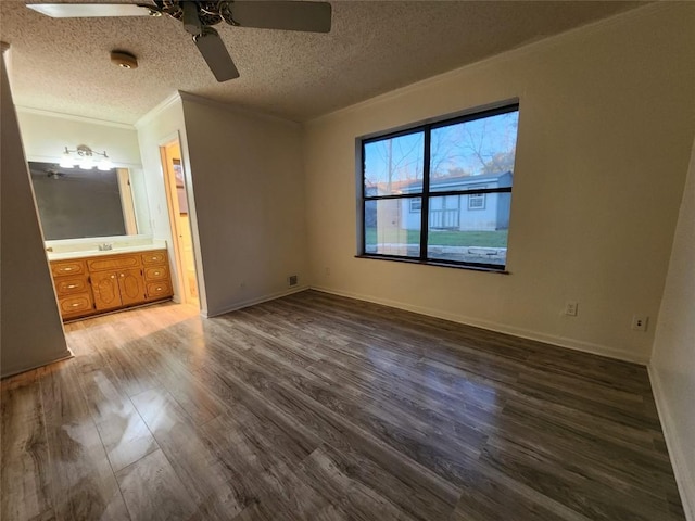 unfurnished bedroom with ornamental molding, ensuite bathroom, hardwood / wood-style floors, and a textured ceiling