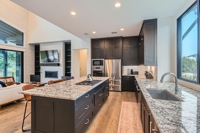 19217 Lost Tree Cv, Spicewood, TX 78669 - kitchen with appliances with stainless steel finishes, healthy amount of natural light, a breakfast bar, light wood finished floors, and recessed lighting