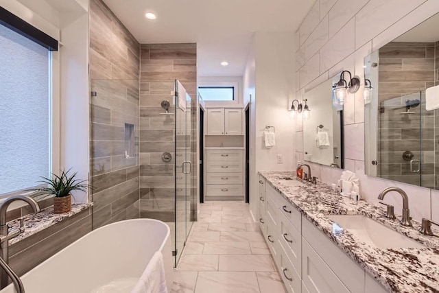 19217 Lost Tree Cv, Spicewood, TX 78669 - bathroom featuring double vanity, a stall shower, a soaking tub, recessed lighting, and marble finish floors