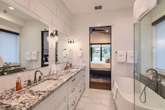 19217 Lost Tree Cv, Spicewood, TX 78669 - ensuite bathroom with marble finish floors, double vanity, and a freestanding bath
