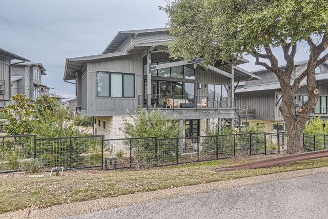 19217 Lost Tree Cv, Spicewood, TX 78669 - view of front of home with board and batten siding and a balcony