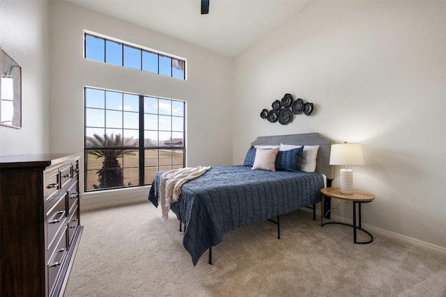 bedroom with multiple windows, high vaulted ceiling, light colored carpet, and ceiling fan