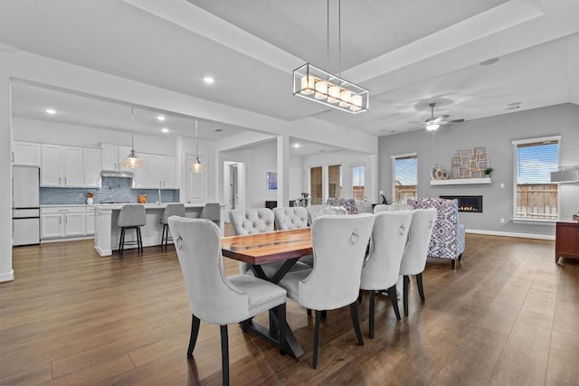 872 Wild Pecan Loop, Buda, TX 78610 - dining room with dark wood finished floors, recessed lighting, a warm lit fireplace, a ceiling fan, and baseboards