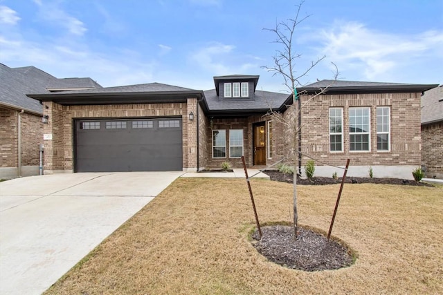 prairie-style home with a garage and a front yard