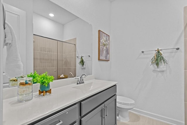 872 Wild Pecan Loop, Buda, TX 78610 - bathroom featuring vanity, toilet, tiled shower, and baseboards