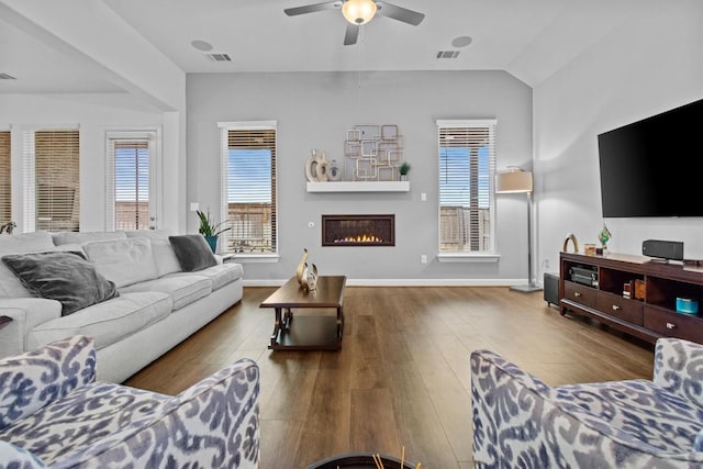 872 Wild Pecan Loop, Buda, TX 78610 - living area featuring ceiling fan, a glass covered fireplace, wood finished floors, baseboards, and vaulted ceiling