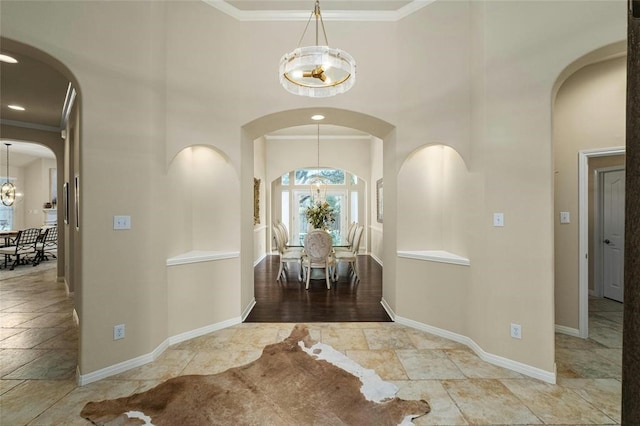 11409 Cezanne Ct, Austin, TX 78726 - foyer with a chandelier, a towering ceiling, baseboards, stone tile flooring, and arched walkways