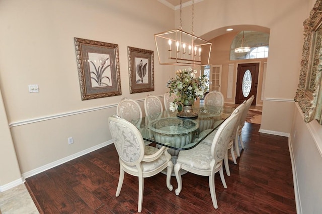11409 Cezanne Ct, Austin, TX 78726 - dining space with a chandelier, wood finished floors, baseboards, crown molding, and arched walkways