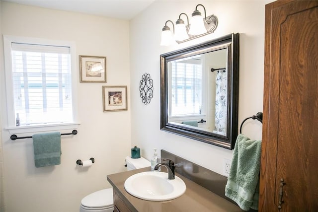 bathroom featuring vanity, a wealth of natural light, and toilet