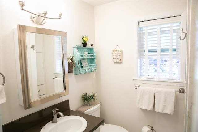 bathroom featuring vanity, toilet, and a healthy amount of sunlight