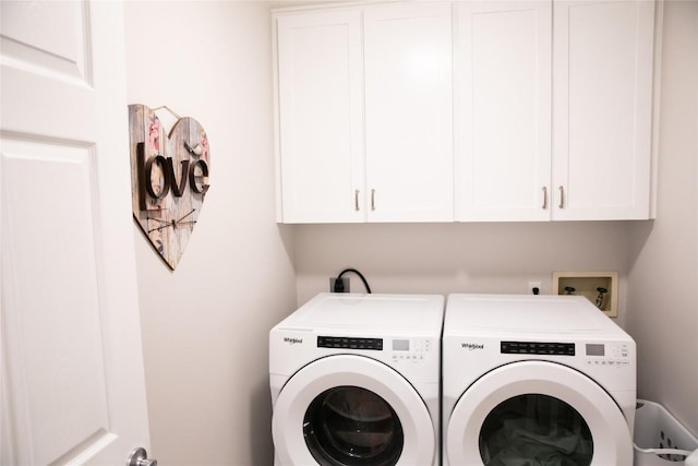 washroom featuring cabinets and separate washer and dryer