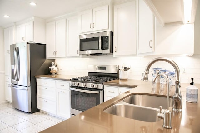 kitchen with sink, light tile patterned floors, white cabinets, stainless steel appliances, and backsplash