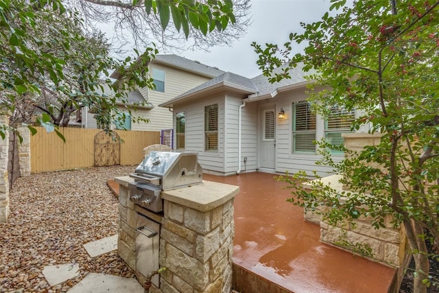 rear view of property featuring exterior kitchen and a patio