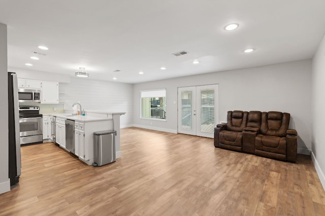 kitchen with french doors, light hardwood / wood-style flooring, kitchen peninsula, stainless steel appliances, and white cabinets