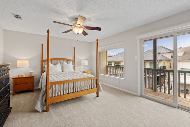 carpeted bedroom featuring access to outside, a textured ceiling, and ceiling fan