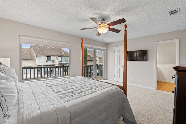 carpeted bedroom featuring ceiling fan, ensuite bath, a textured ceiling, and access to outside