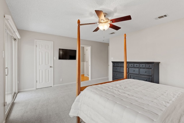 carpeted bedroom featuring ceiling fan and a textured ceiling