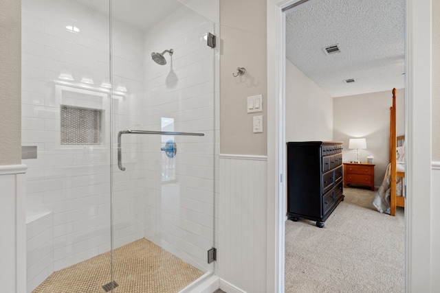 bathroom with a shower with door and a textured ceiling