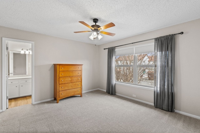 unfurnished bedroom with ceiling fan, light colored carpet, a textured ceiling, and ensuite bathroom