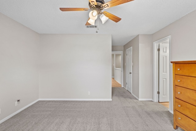 empty room with light carpet, a textured ceiling, and ceiling fan