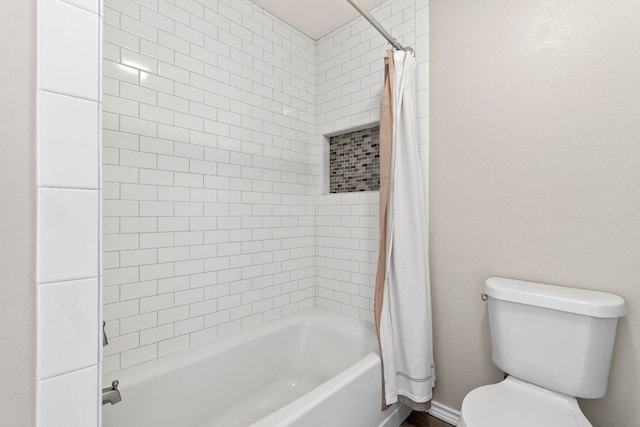 bathroom featuring shower / tub combo and toilet