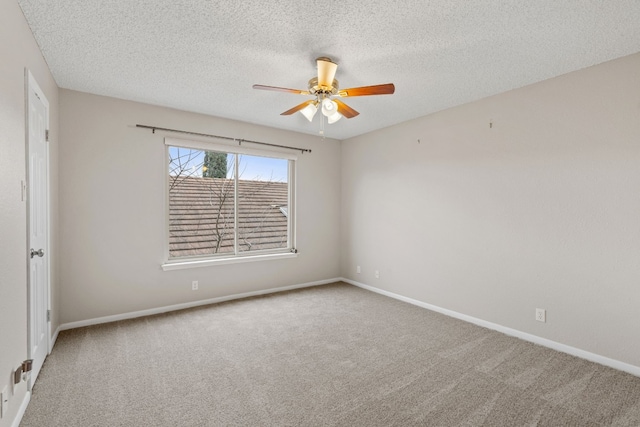 carpeted empty room with ceiling fan and a textured ceiling