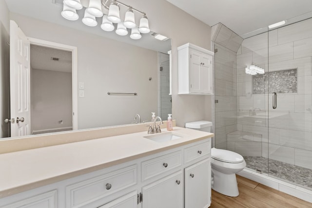 bathroom featuring vanity, toilet, an enclosed shower, and wood-type flooring