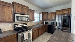 kitchen with stainless steel appliances, sink, and backsplash