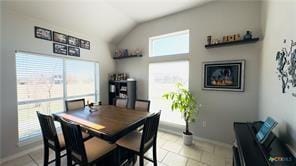 tiled dining room featuring a wealth of natural light and vaulted ceiling