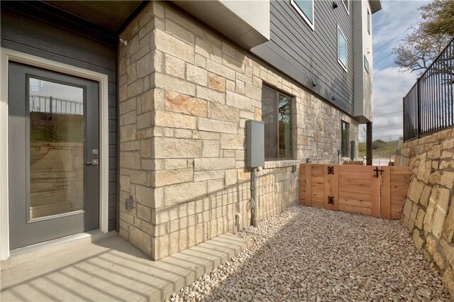 2050 Lohmans Spur Rd Unit 102, Lakeway, TX 78734 - view of side of property with a gate and stone siding