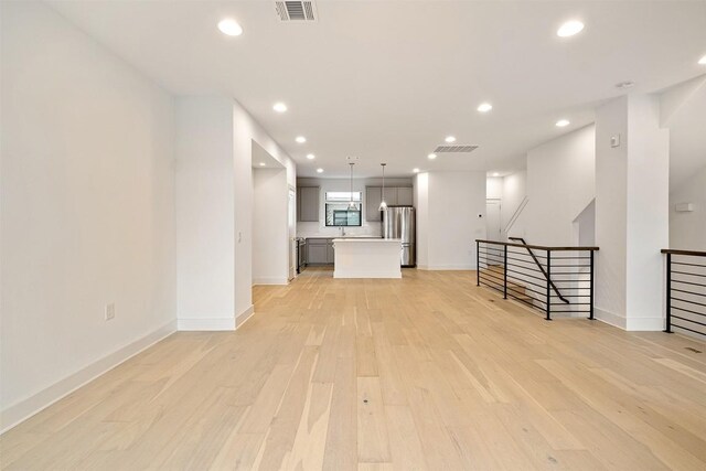 2050 Lohmans Spur Rd Unit 102, Lakeway, TX 78734 - unfurnished living room featuring light wood-style floors and recessed lighting