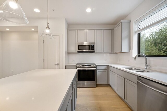 2050 Lohmans Spur Rd Unit 102, Lakeway, TX 78734 - kitchen featuring appliances with stainless steel finishes, gray cabinetry, light wood-style flooring, tasteful backsplash, and recessed lighting