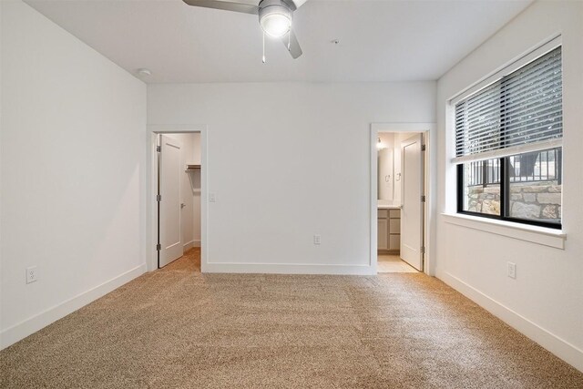 2050 Lohmans Spur Rd Unit 102, Lakeway, TX 78734 - unfurnished bedroom with light colored carpet, a walk in closet, ensuite bathroom, and a ceiling fan