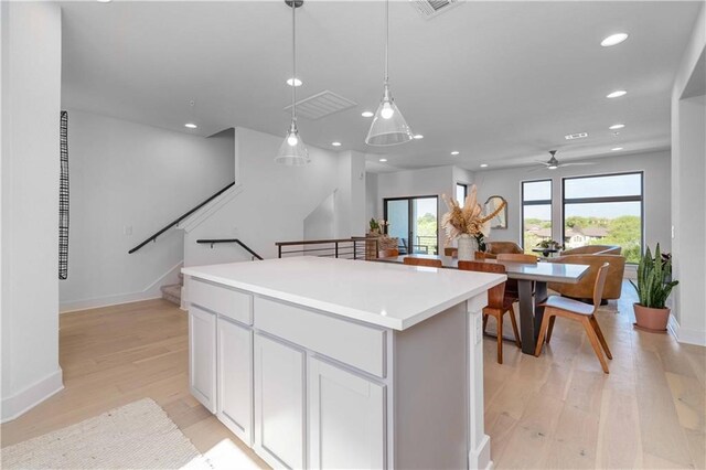 2050 Lohmans Spur Rd Unit 102, Lakeway, TX 78734 - kitchen featuring a kitchen island, light wood finished floors, ceiling fan, decorative light fixtures, and recessed lighting