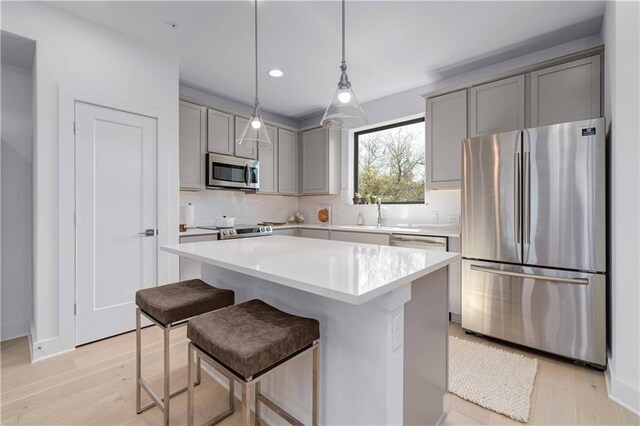 2050 Lohmans Spur Rd Unit 102, Lakeway, TX 78734 - kitchen with appliances with stainless steel finishes, gray cabinets, light wood-type flooring, and recessed lighting