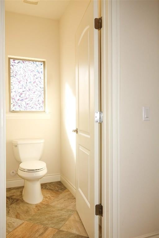 bathroom featuring baseboards and toilet