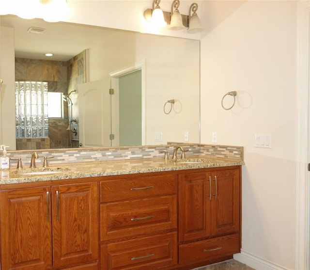 full bath with a sink, decorative backsplash, visible vents, and double vanity